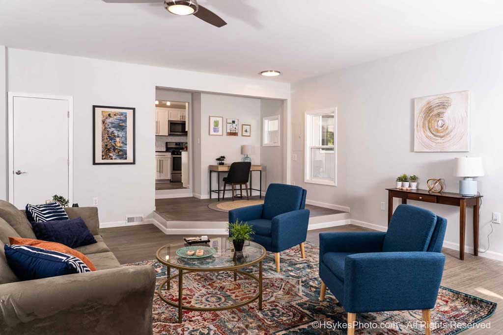 Living room with a work area in the background and doorway into the kitchen