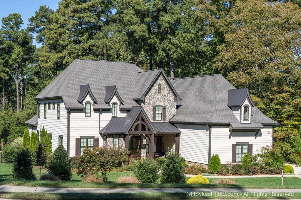 Home with arched metal roof accent dormers