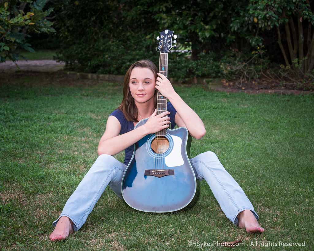 Senior Photo of a girl in jeans with a guitarh by Howard Sykes