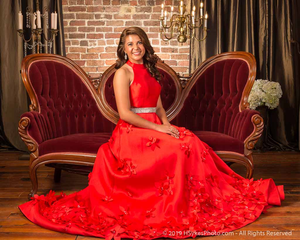 Portrait of a senior in a formal red dress photographed by Howard Sykes